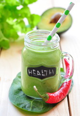 Green vegetable smoothie isolated on wood background
