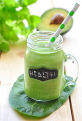 Green vegetable smoothie isolated on wood background