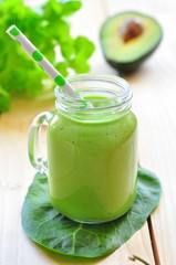 Green vegetable smoothie isolated on wood background