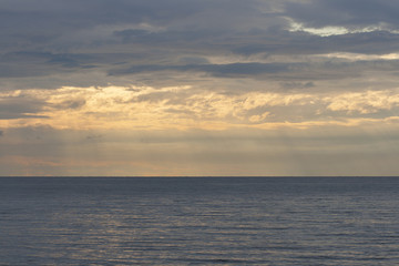 light rays falling through clouds on the sea surface