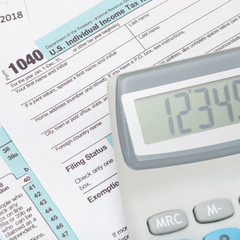 Calculator over US 1040 Tax Form - studio shot