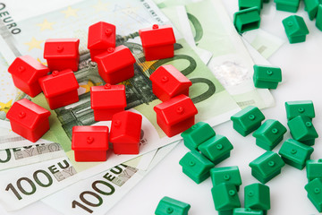 Obraz premium Small toy houses and money