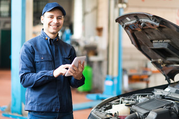 Mechanic using a tablet in his garage
