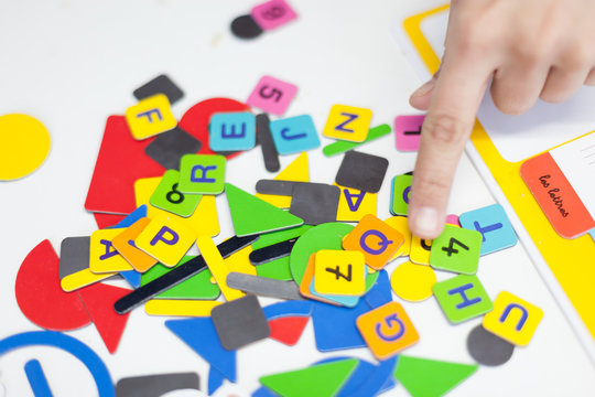 Close up of a person's hand showing multi-coloured alphabet