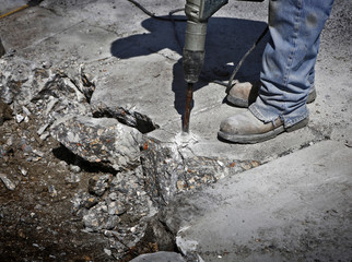 Man drilling cement concrete road