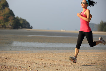 young healthy lifestyle woman running at sunrise beach