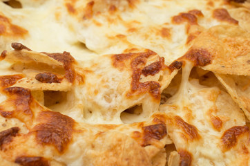 Tortilla chips covered with a thick layer of mozarella cheese
