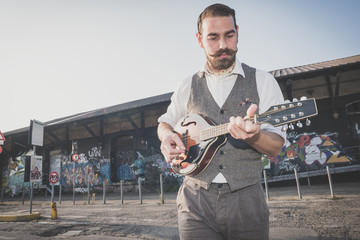 handsome big moustache hipster man playing mandolin
