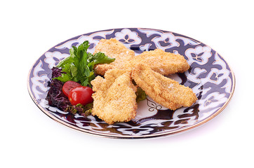 pile of chicken nuggets on white plate with sauce