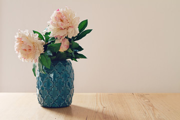 Blue moroccan style vase of large white and pink flowers