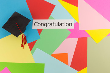 Graduation cap and word on colorful paper background