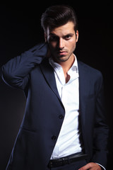 Handsome young business man holding one hand to his neck.