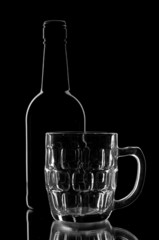 empty cup and bottle on a black background.