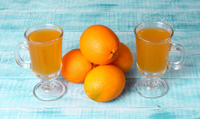 Orange juice in glass, fresh fruits on wooden background