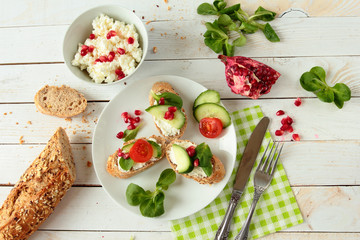 Plate with bread with cheese, lettuce, tomato and pomegranate