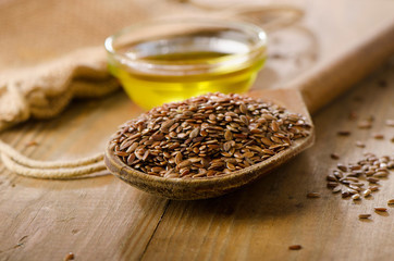 Brown flax seeds on a spoon and flaxseed oil