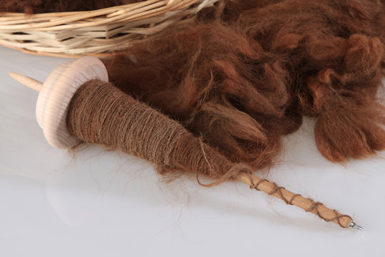Braune Alpakawolle mit der Handspindel gesponnen