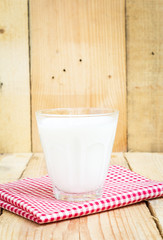 Glass of milk on wooden background