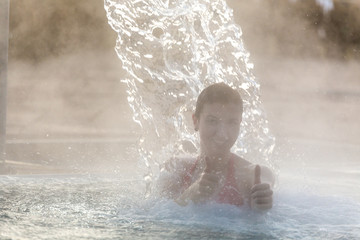 Young woman relaxing in thermal pool.