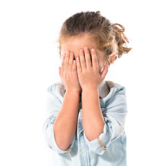 Blonde kid covering her eyes