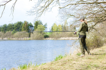 Fototapeta na wymiar woman fishing at pond in spring