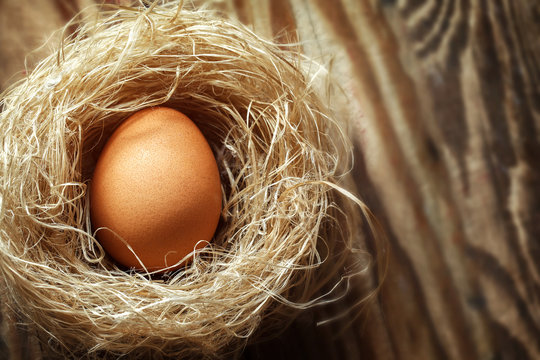 Eggs in the nest on old wooden table background, top view