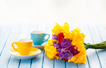 Two cups of coffee and bouquet of flowers