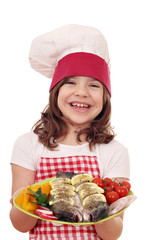 happy little girl cook with fish