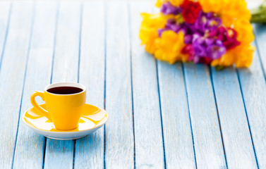 Cup of coffee and bouquet of flowers