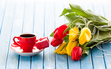 Cup and gift box with bouquet of tulips