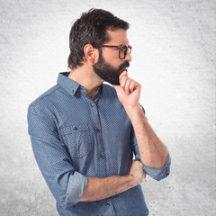 Young hipster man thinking over white background