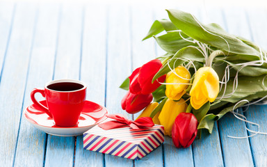 Cup and gift box with bouquet of tulips