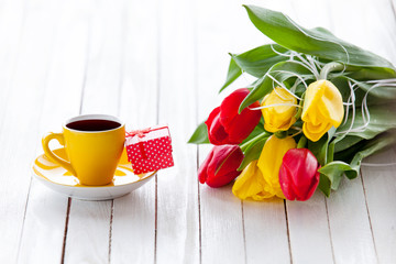 Cup and gift box with bouquet of tulips