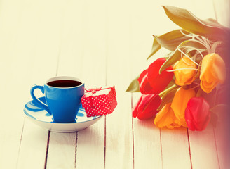 Cup and gift box with bouquet of tulips