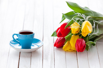 Cup of coffee and bouquet of tulips