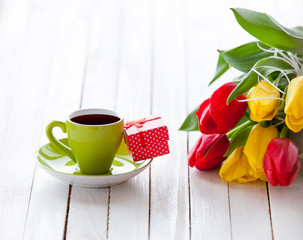 Cup and gift box with bouquet of tulips