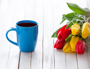 Cup of coffee and bouquet of tulips