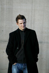 young man leaning on wall