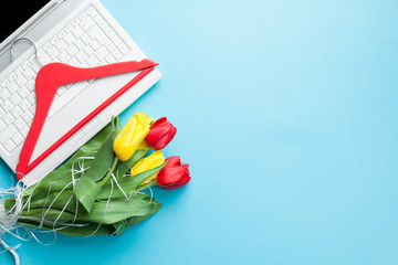White computer and bouquet of tulips with hange