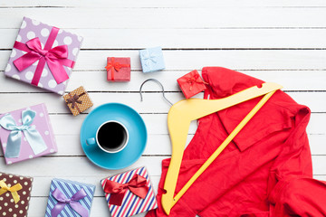 Cup of coffee and gifts with clothes