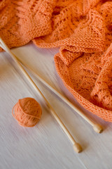 Bright orange plaid knitted, knitting needles and yarn balls