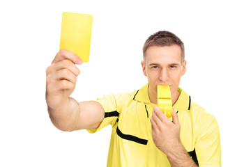 Referee showing yellow card and blowing huge whistle