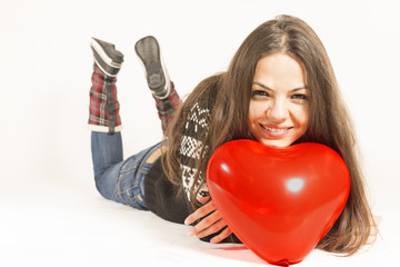 Woman wearing winter clothing with heart shaped balloon