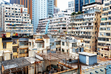 Naklejka premium W Hongkongu stare domy otaczały nowoczesne drapacze chmur
