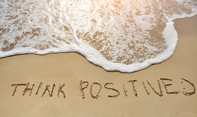 think positive written on sand beach - positive thinking concept