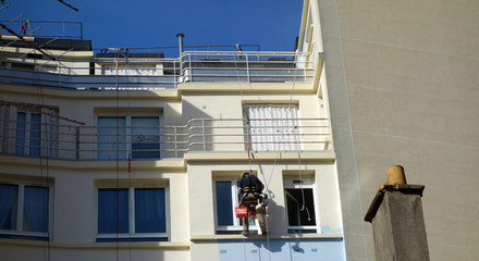 Un peintre en bâtiment sécurisé en suspension dans le vide