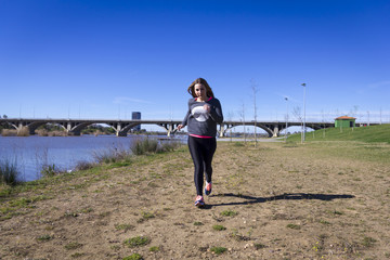 Chica joven haciendo ejercicio junto al rio