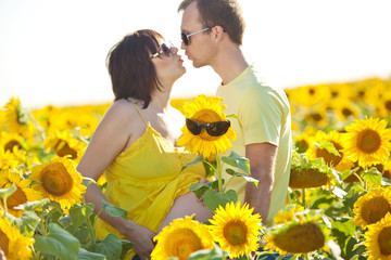 Husband with pregnant wife is resting in nature. 