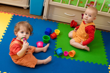 the boy and the girl play on a nursery floor