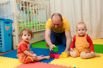 the boy and the girl play on a nursery floor
